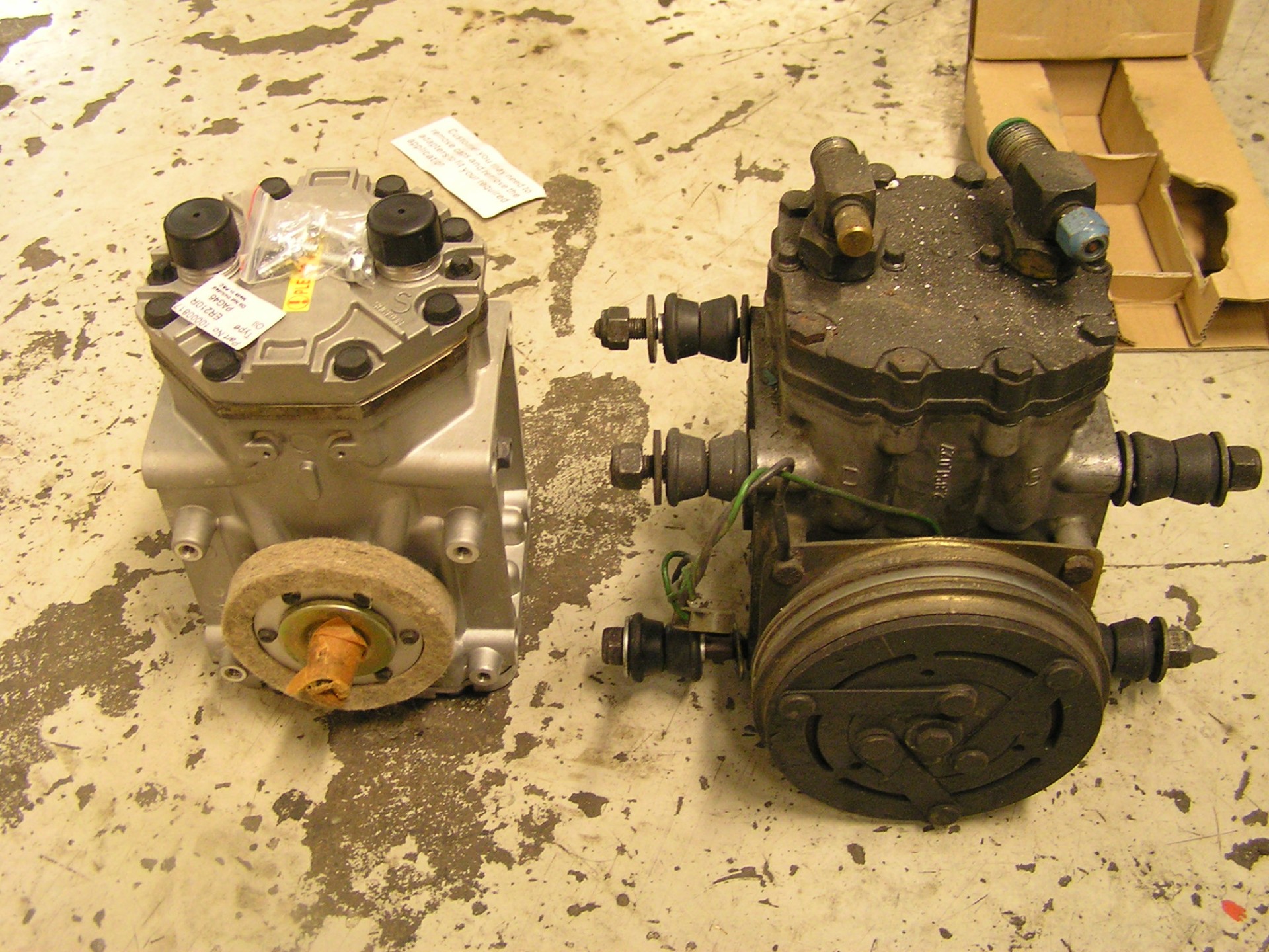 New and old A/C compressors side by side — replaced during the 2021 Autokinito service