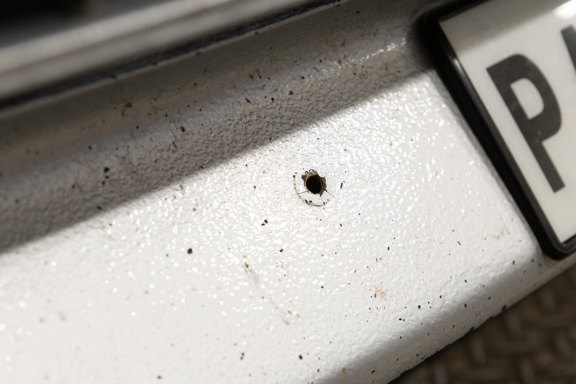 Drilled hole in bumper next to number plate